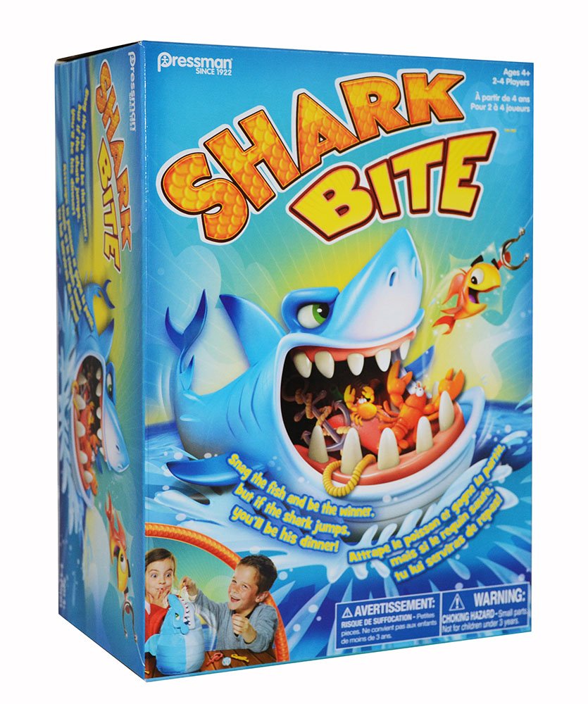 Colorful box for SHARK BITE GAME - BILINGUAL featuring a large cartoon shark with its mouth open, small fish, a crab, fishing rod, two excited children playing, and safety warnings.